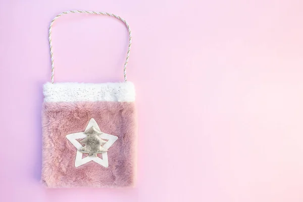 Pembe arka planda hediyeler olan Noel çantası.