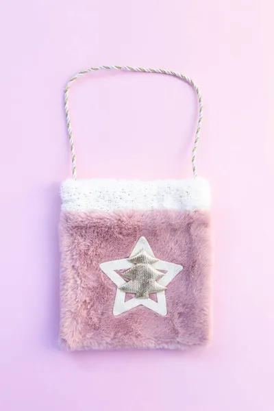 Pembe arka planda hediyeler olan Noel çantası.