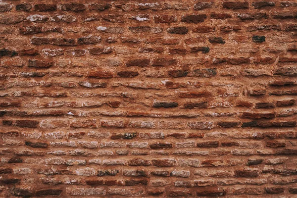 Red dark brick wall, dirty damaged background, cracked texture.