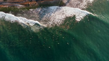 Beautiful view of the sea and the ocean with surfers waiting for the waves.