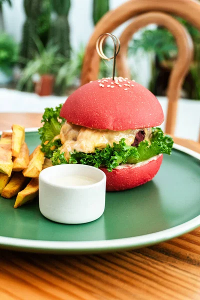 Vejetaryen burger, kırmızı çörek, patates kızartması, yeşil tabak, ahşap masa, sağlıklı vejetaryen yemeği..