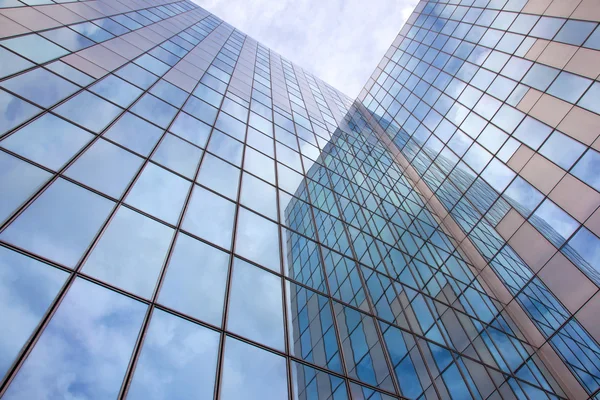 Moderna fachada azul de vidrio y acero con cielo nublado —  Fotos de Stock