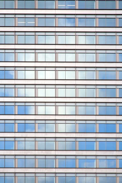 反映出白色云的办公大楼的外观 — 图库照片