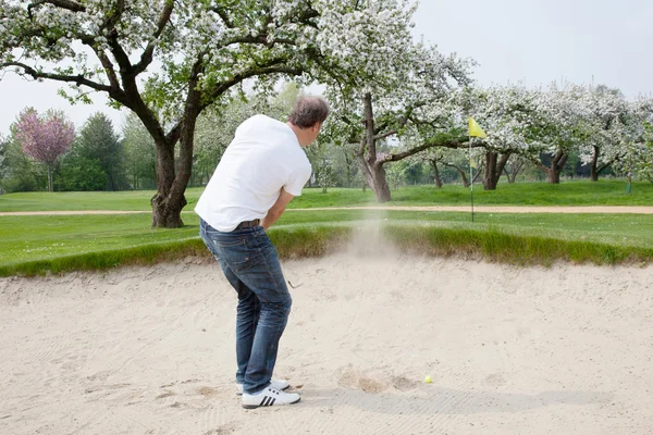 Férfi gyakorló golf közelében virágzó orchard — Stock Fotó