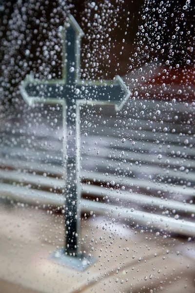 Cross in hearse and raindrops on window pane — Stock Photo, Image