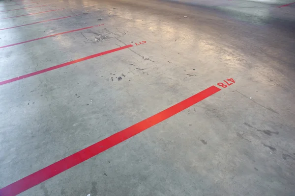 Red lines and numbers in empty parking garage — Stock Photo, Image