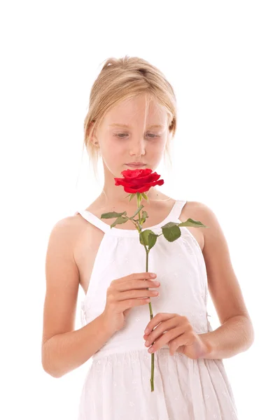 Jong meisje in witte jurk ruiken een roos — Stockfoto