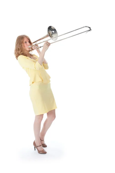 Jovem mulher em mini vestido amarelo tocando o trombone — Fotografia de Stock