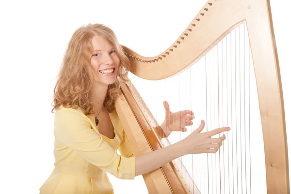 Dziewczyna w żółty grający na harfie — Zdjęcie stockowe