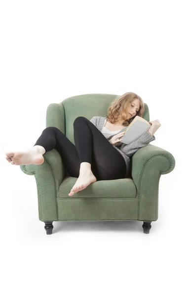 Młoda ładna kobieta, czytanie książki w fotel — Zdjęcie stockowe