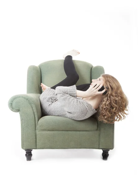 Молодая симпатичная женщина на телефоне в кресле — стоковое фото
