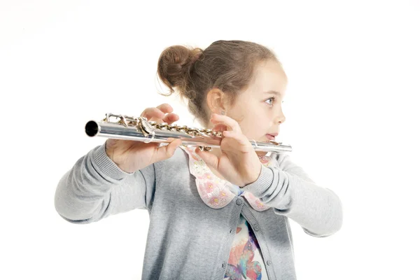 年轻的姑娘演奏长笛 免版税图库照片