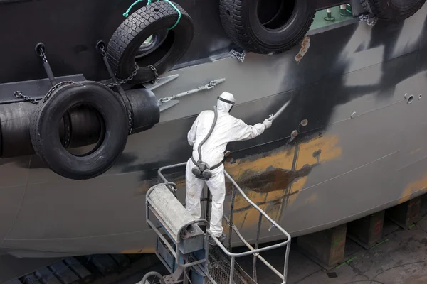 Muž sprej malování hood lodi Stock Snímky