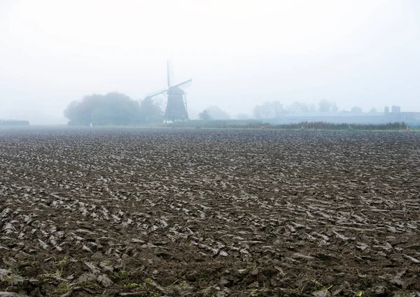 Campo recién arado y silueta de molino de viento en los Países Bajos durante el otoño —  Fotos de Stock