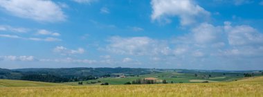 Belçika 'nın Lüksemburg eyaleti Longvilly ve çevresindeki renkli tarlalar yazın bulutlu gökyüzünün altında