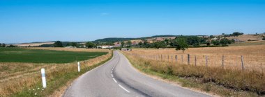 Fransız yazında mavi gökyüzünün altında köy ve kırsal lorraine arazilerine giden köy ve tarlalara giden yol.
