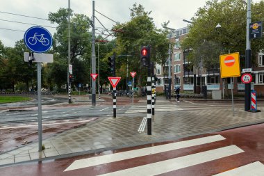 Amsterdam 'da yaya geçidi, trafik işaretleri ve bisikletçiler için trafik ışıkları ve taşımacılık.