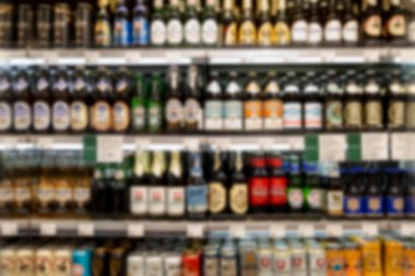 Dükkandaki raflarda farklı markalardan biralar var. Alkolsüz içecekler. Bulanık. Ön görünüm.