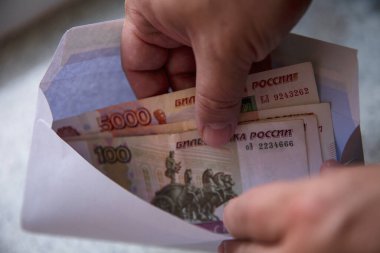 Adam bir zarftan Rus rublesini çıkarıyor. Yakın plan. Kara ücretler ve rüşvetler.