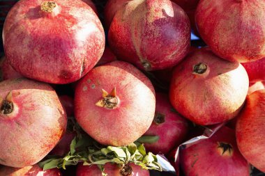 Market tezgahında olgun narlar. Lezzetli mevsimlik meyveler. Soğuk mevsiminde doğadan gelen vitaminler ve sağlık. Yakın plan..