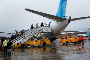 İnsanlar havaalanındaki uçağa binmek için merdivenden iniyor. Moskova, Rusya, 10-28-2021.