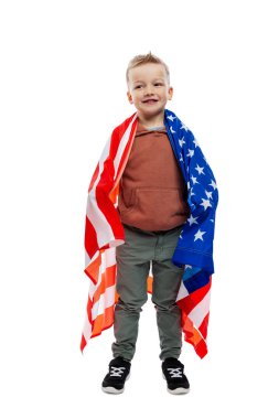 Amerikan bayrağıyla gülümseyen çocuk. Bağımsızlık Günü kutlaması ve vatanseverlik. Tam yükseklik. Beyaz arka planda izole edilmiş. Dikey.
