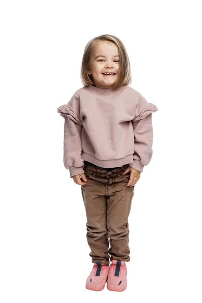 Dziewczynka Stoi Się Śmieje Słodkie Dziecko Brązowych Dżinsach Różowym Swetrze — Zdjęcie stockowe