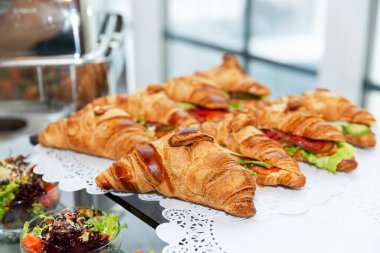 Büfe masasında sandviçli kruvasan. Kahve molası ve iş toplantıları. Yakın plan..