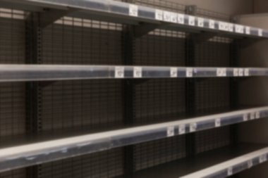 Markette fiyat etiketi olan boş raflar. Panik ve yemek krizi. Yan görüş. Bulanık.