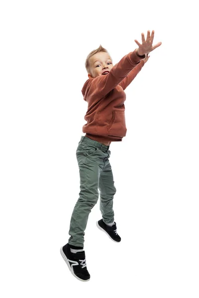 那个快乐的男孩在跳 穿牛仔裤和棕色毛衣的那个人 活动和行动 被白色背景隔离 垂直方向 — 图库照片