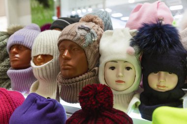 Vitrindeki mankenlerin kafalarına sıcak şapkalar örerdi. Soğuk mevsimlerde moda. Yakın plan..
