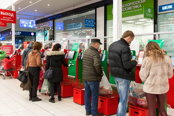 Bir süpermarkette bir dizi kırmızı ödeme terminali. Modern ödeme sistemi. İnsanlar servisi kullanıyor. Yan görüş. Moskova, Rusya, 12-17-2021.