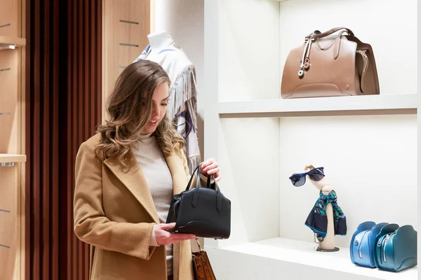 Young Woman Chooses Elegant Leather Bag Store Beautiful Blonde Beige — стоковое фото