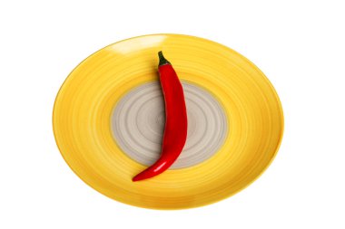 Parlak sarı bir tabakta kırmızı bir biber sürüsü. Diyet ve sağlıklı beslenme. Beyaz arkaplanda izole.