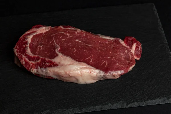 Siyah Taş Bir Tahtanın Üzerinde Çiğ Mermer Biftek Sağlıklı Yiyecekler — Stok fotoğraf