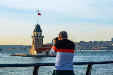 Bir adam Uskudar 'dan Maiden' s Tower 'ın ya da İstanbul' un fotoğrafını çekiyor. Türkiye 'de turizm. İstanbul arka plan fotoğrafı.
