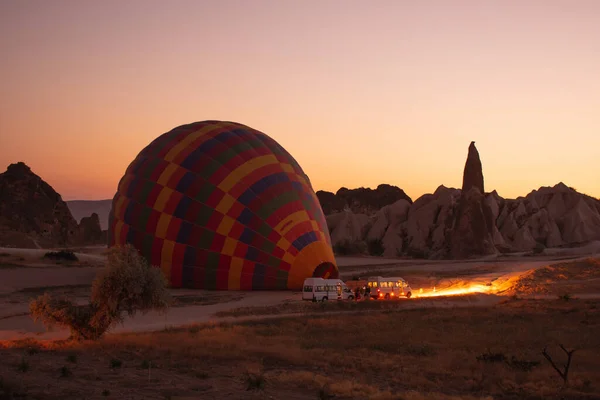 Hot air balloons are getting ready to fly at sunrise in Cappadocia Turkey. Blowing hot air to the hot air balloons.