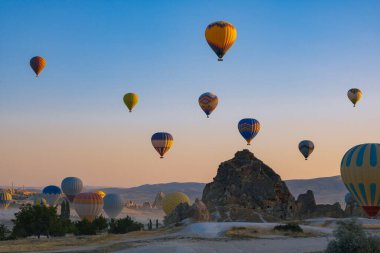 Kapadokya 'da sıcak hava balonları ve peri bacaları. Kapadokya arka plan fotoğrafı. Goreme 'de sıcak hava balonu faaliyeti. 