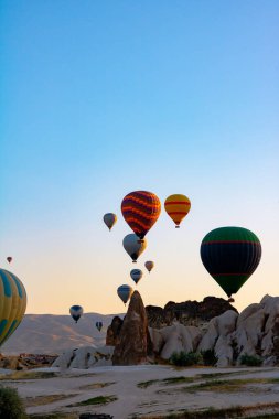 Kapadokya 'da sıcak hava balonları ve peri bacaları. Kapadokya arka plan fotoğrafı. Goreme 'de sıcak hava balonu faaliyeti. 
