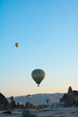 Kapadokya 'da sıcak hava balonları ve peri bacaları. Kapadokya arka plan fotoğrafı. Goreme 'de sıcak hava balonu faaliyeti. 