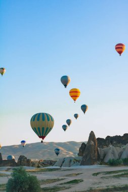 Kapadokya 'da sıcak hava balonları ve peri bacaları. Kapadokya arka plan fotoğrafı. Goreme 'de sıcak hava balonu faaliyeti. 