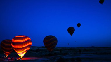 Sıcak hava balonu Kapadokya 'da gün doğumunda havalanmaya hazırlanıyor. Kapadokya Türkiye 'de sıcak hava balonu turu. Türkiye 'de turizm.
