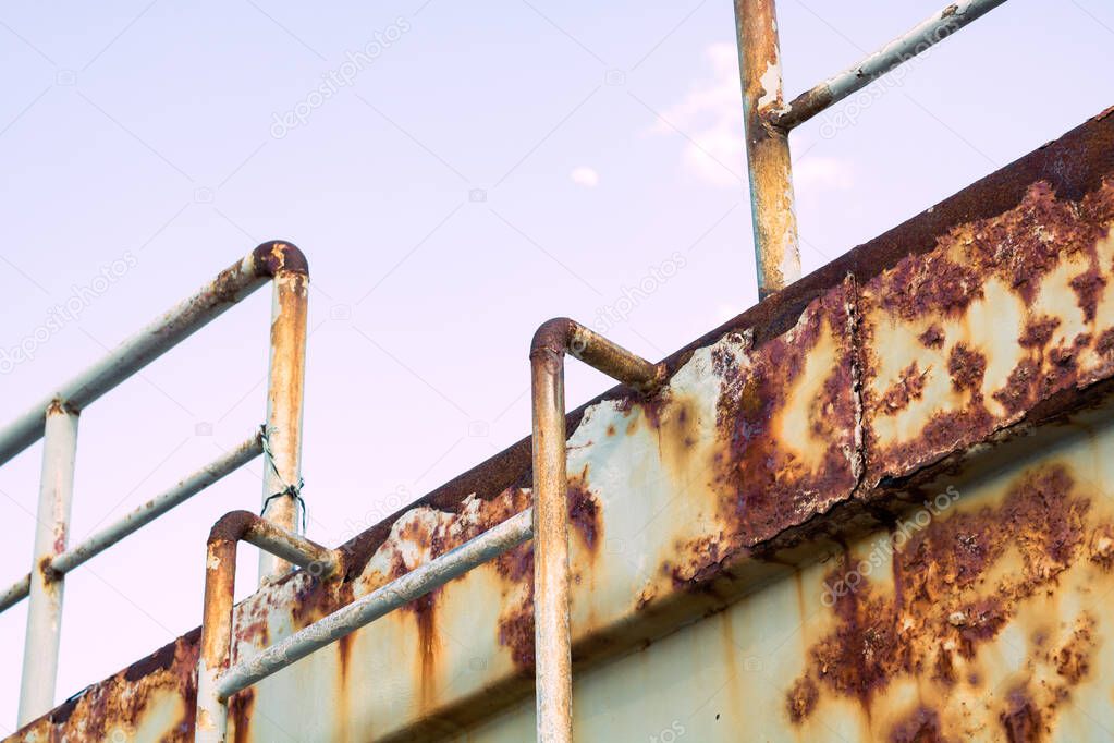 Rusty ship. Rusty boat with ladder and handrails. Vintage boat. Ship recycling industry background.