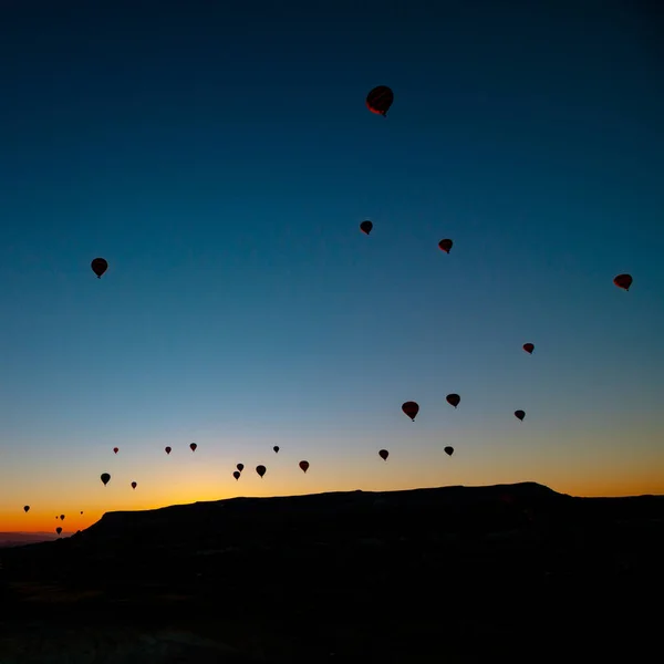 Globos de aire caliente. Silueta de globos de aire caliente al amanecer en Capadocia —  Fotos de Stock