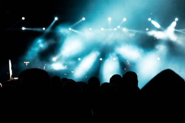 Konser arkaplanı. Konser arkaplan fotoğrafındaki kalabalığın silueti. Sahne ışıkları, sahne ışıkları ve sisli efektler. Gürültü Efekti.