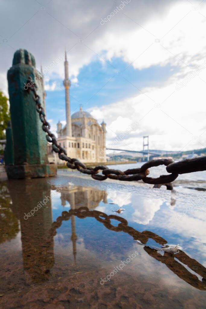 Ortakoy Mosque. Reflection of the Ortakoy Mosque on the puddle. Istanbul background photo. Ramadan or islamic background photo.
