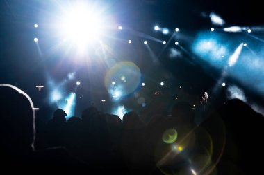 Konser arka planı fotoğrafı. Konser salonunda ışıklar yanıp sönüyor ve lensler yanıp sönüyor. İnsanların silueti. Gürültü Efekti