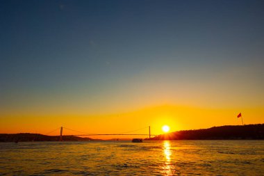 İstanbul arka plan fotoğrafı. Günbatımında Boğaziçi Köprüsü 'nün geniş açılı görüntüsü veya 1 Temmuz şehitleri köprüsü.