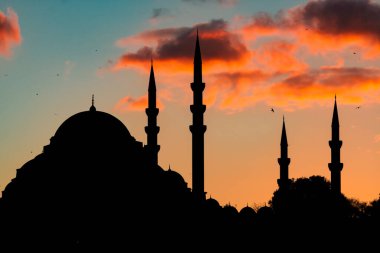 İslami arkaplan. Gün batımında bulutlarla birlikte Süleyman Camii 'nin silueti. Ramazan veya kandil veya iftar veya laylat el Kadir veya İslami arkaplan fotoğrafı. Gürültü etkisi dahil.