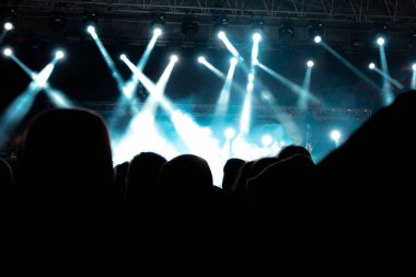 Konser arkaplanı. Sis etkisi ve sahne ışıkları. Konserdeki insanların silueti. Gürültü etkisi dahil.